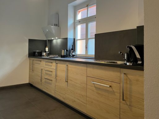 Küche Küche mit Küchenzeile, Herd, Spülbecken, Kühlschrank, Gefrierfach, Kaffeemaschine, Toaster, Wasserkocher, Geschirr und Besteck