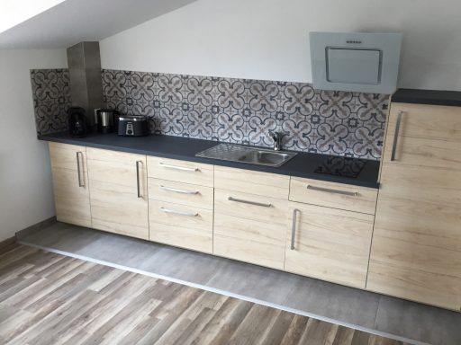 Küche Küche mit Küchenzeile, Herd, Spülbecken, Kühlschrank, Gefrierfach, Kaffeemaschine, Toaster, Wasserkocher, Geschirr und Besteck